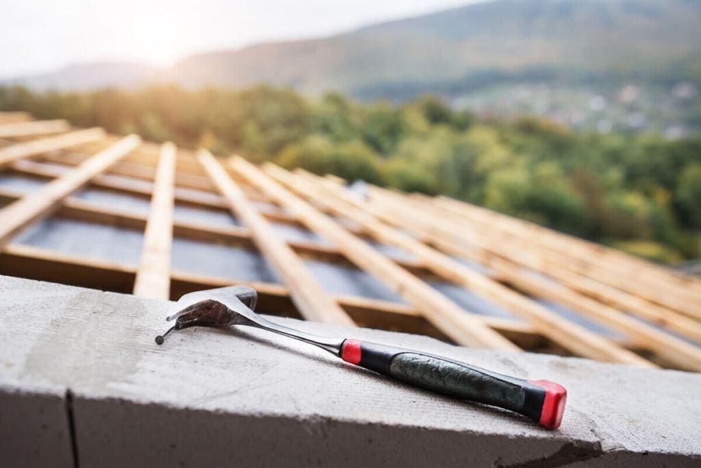 hammer laying on top of an under construction roof