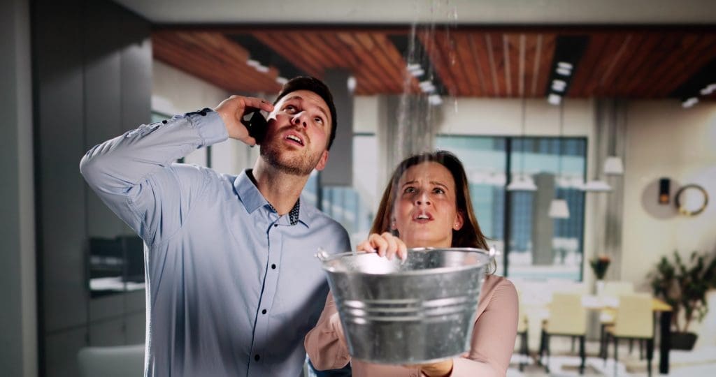 Couple on phone scheduling emergency roof repair