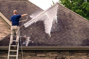 Daniel Hood Roofing team using low-pressure soft wash to remove black mold from roof.
