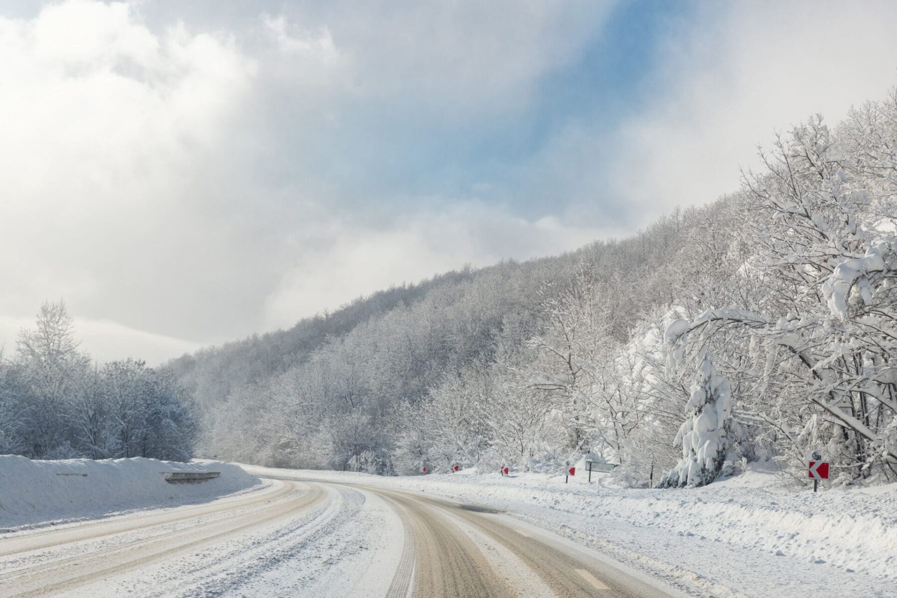 Scenic view of curve turn on beautiful mountain forest cpuntry woods highway road at cold snowy sunny weather winter day. Wintry frosty route landcape. Travel season journey trip drive.
